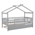 Twin size wooden house bed with attached trundle, featuring a cozy house-shaped frame and natural wood finish for a child's bedroom.