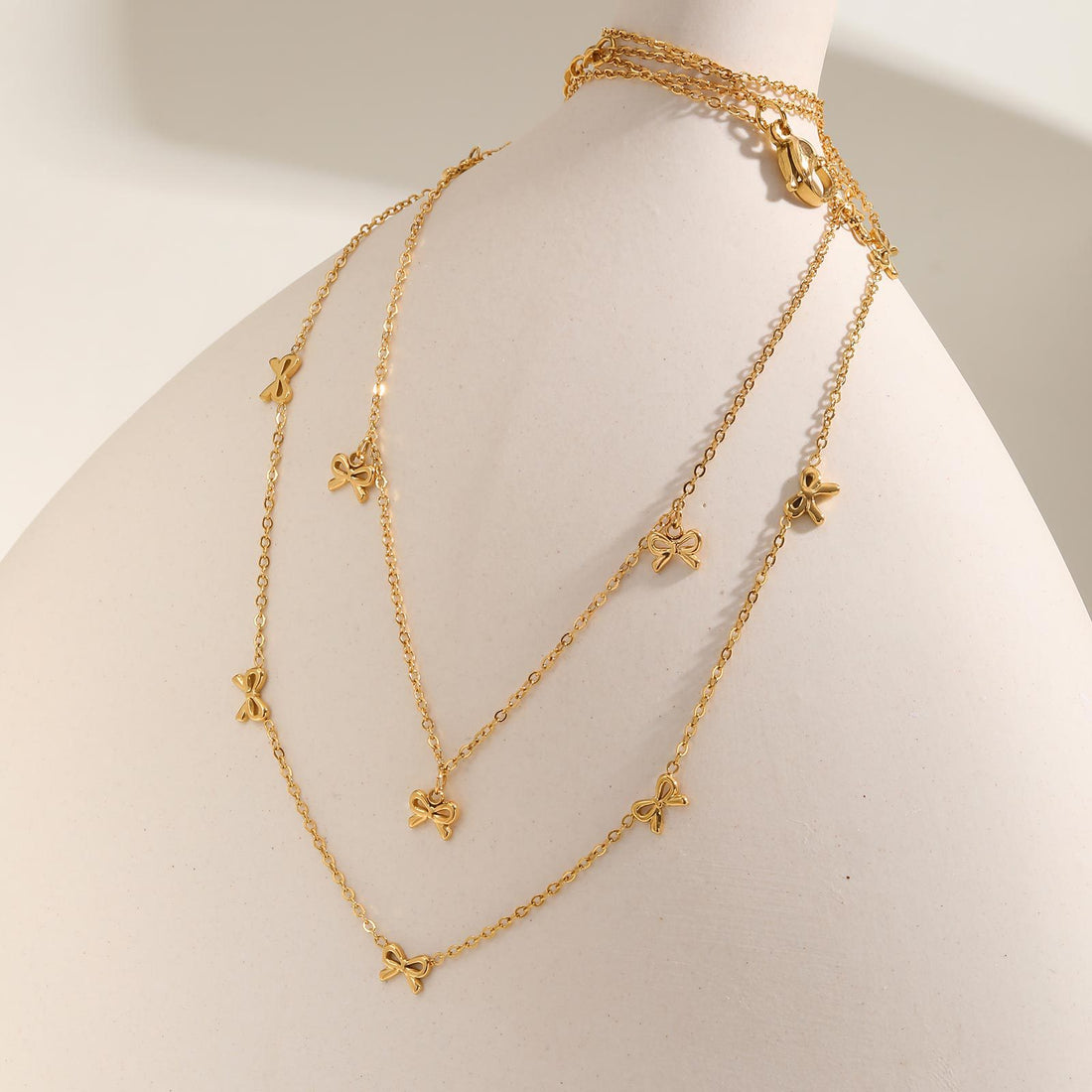 European and American style stainless steel necklace with flat cross and bow design, featuring a sleek, polished finish.
