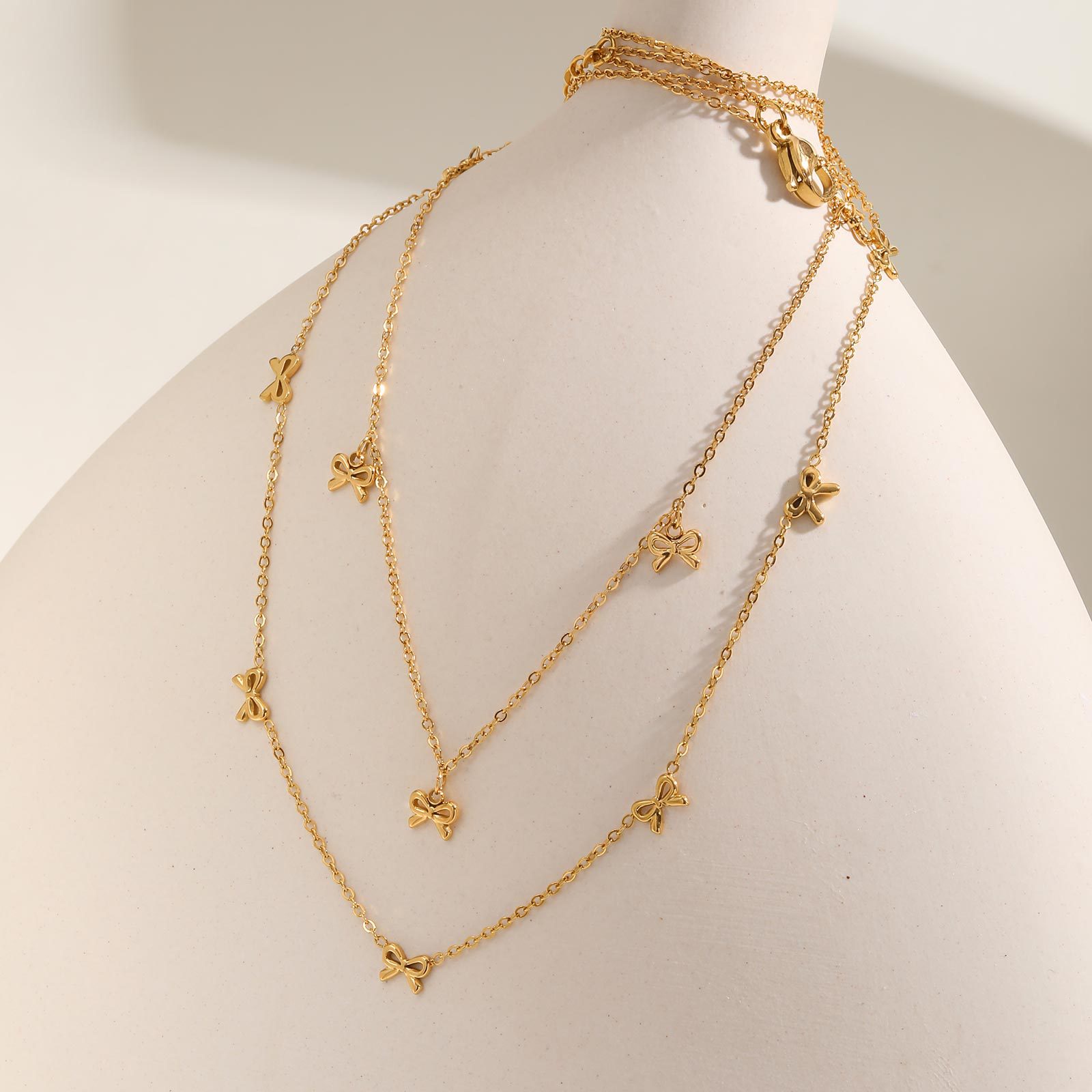 European and American style stainless steel necklace featuring a flat cross chain with a bow design.