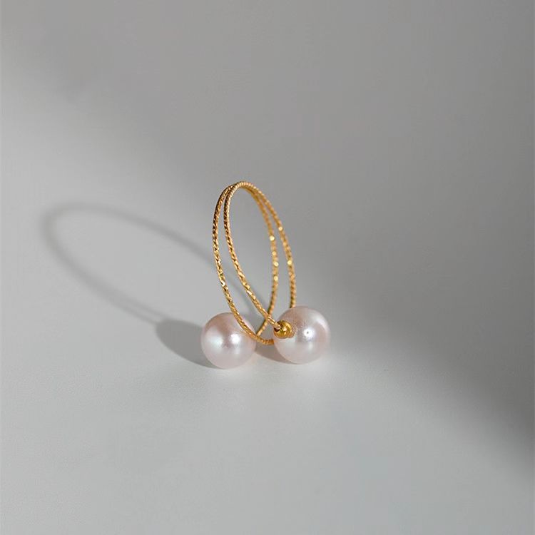 Close-up of a double freshwater pearl open ring featuring two elegant, lustrous pearls on a sleek silver band.