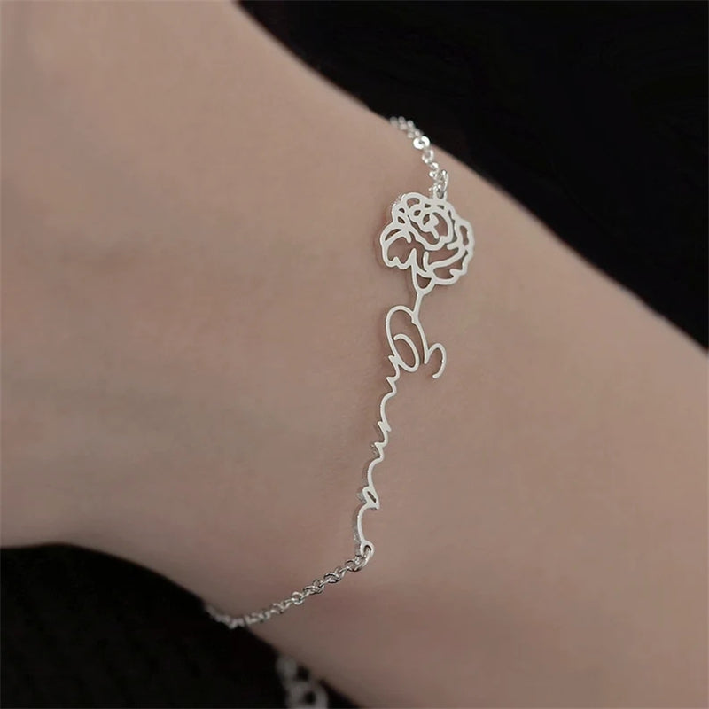 Personalized birthday flower birthstone bracelet with floral charm and birthstone accent, crafted in sterling silver.
