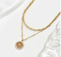 Silver chain paired with a crystal medal pendant, showcasing a delicate and elegant jewelry design.