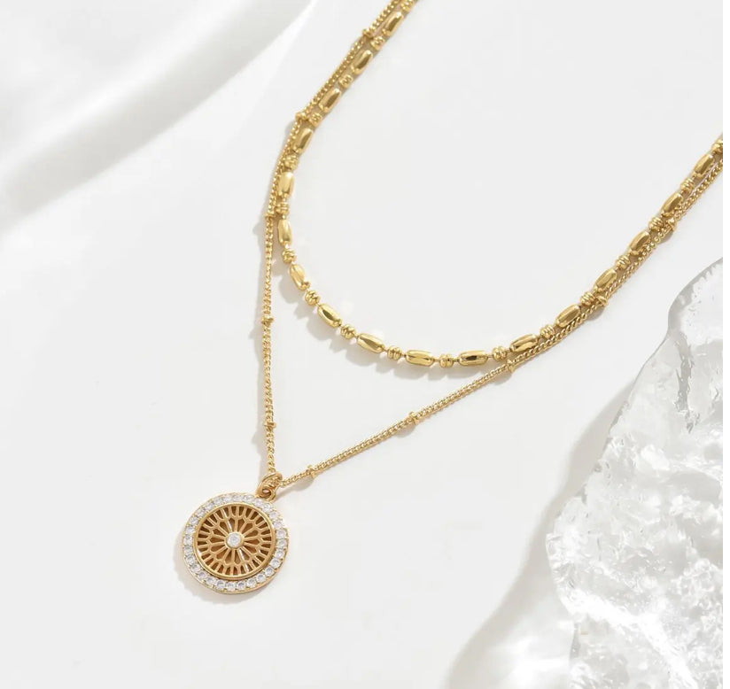 Silver chain paired with a crystal medal pendant, showcasing a delicate and elegant jewelry design.