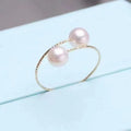 Elegant open ring featuring two freshwater pearls, showcasing a delicate design and lustrous pearl accents on a silver band.