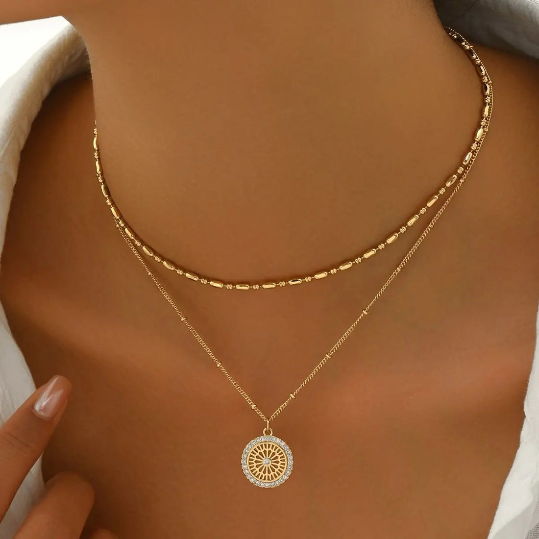 Silver chain paired with a crystal medal pendant, showcasing a delicate jewelry piece with sparkling crystal accents.