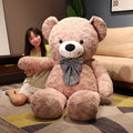 Soft giant plush teddy bear with a bow tie, featuring fluffy fur and a friendly, cuddly appearance.