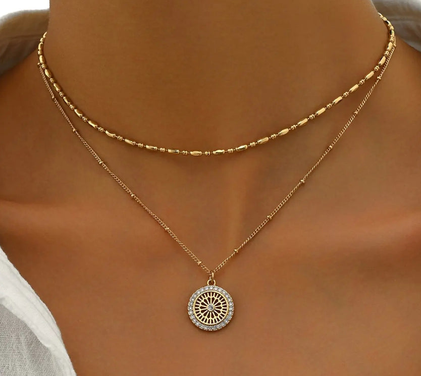 Silver chain paired with a crystal medal pendant, showcasing a delicate jewelry piece with sparkling crystal accents.