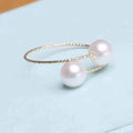 Elegant open ring featuring two freshwater pearls on a sleek band, showcasing timeless jewelry craftsmanship.