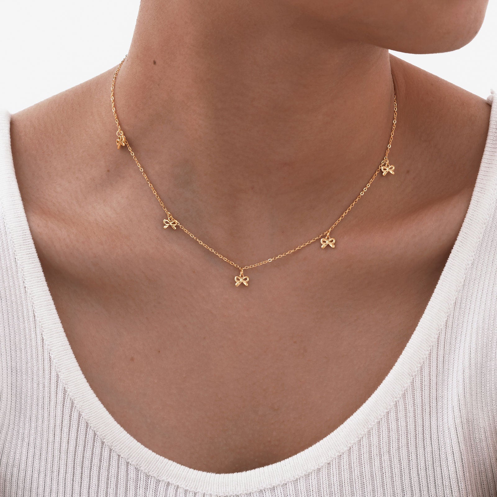European and American style stainless steel necklace featuring a flat cross pendant and bow design.