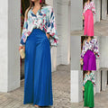 Vibrant abstract print blouse and wide-leg trousers set, stylish fashion ensemble with colorful patterns and flowing fabric.