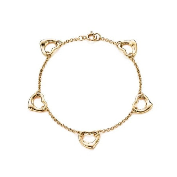 Gold plated open heart station chain bracelet with delicate links and heart charms, perfect for elegant jewelry styling.