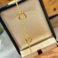 Gold plated open heart station chain bracelet with delicate heart charms, elegant jewelry accessory.