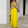 Vibrant abstract print blouse and wide-leg trousers set featuring bold colors and stylish, flowing fabric.