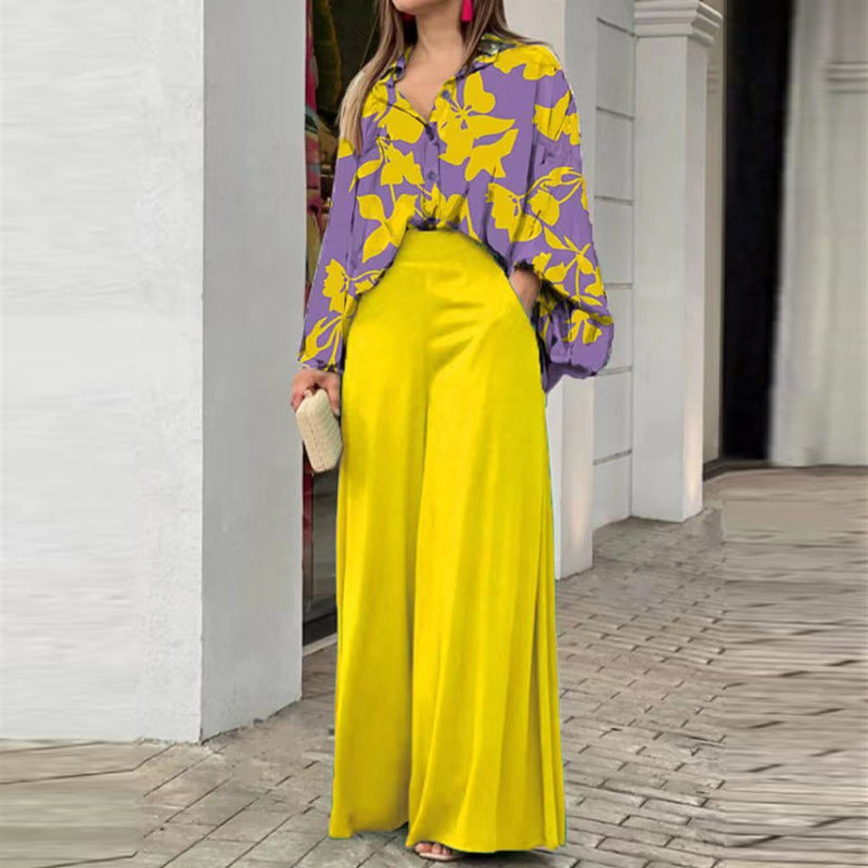 Vibrant abstract print blouse and wide-leg trousers set featuring bold colors and stylish, flowing fabric.