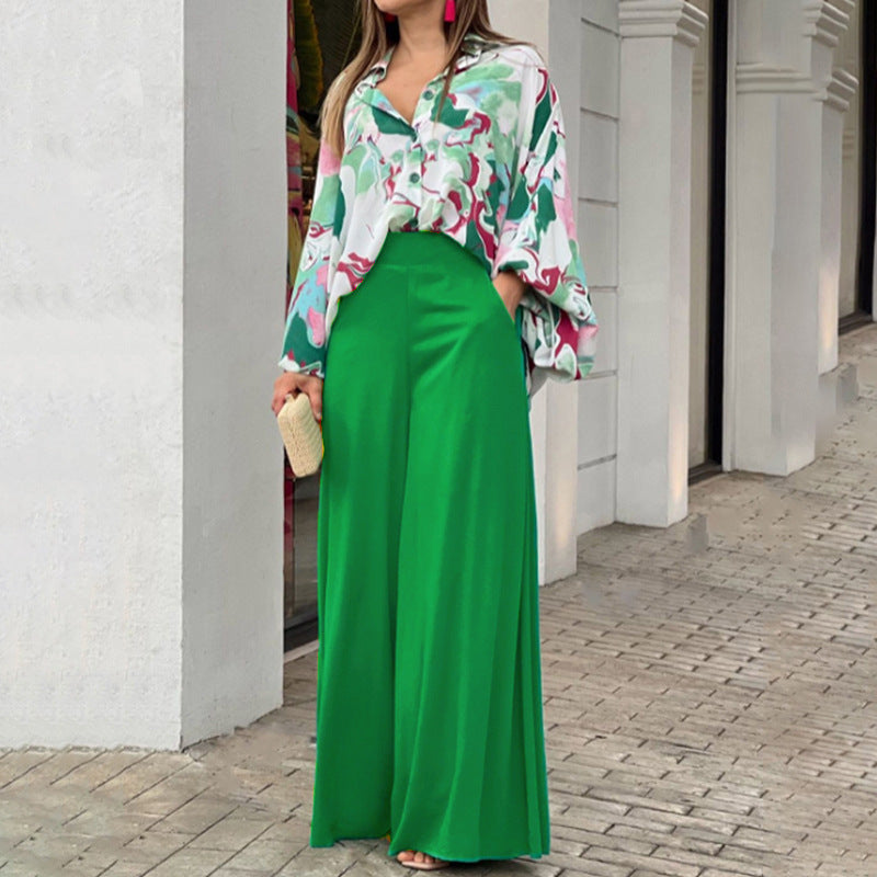 Vibrant abstract print blouse and wide-leg trousers set with bold colors and flowing fabric, perfect for stylish casual wear.