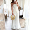 Off-shoulder sleeveless white pantsuit with buttons in a slim-fit design.