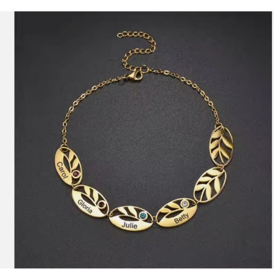 Stainless steel hollow oval leaf engraved bracelet with a colorful birthstone accent, elegant jewelry accessory.