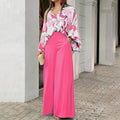 Vibrant abstract print blouse and wide-leg trousers set, stylish and colorful fashion ensemble on a model.