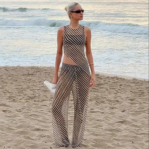 Women's sleeveless diagonal stripes see-through irregular top suit on beach.