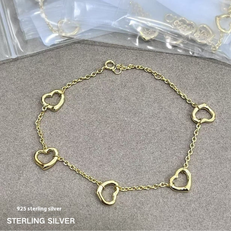 18K gold plated open heart station chain bracelet with delicate heart charms and elegant design.