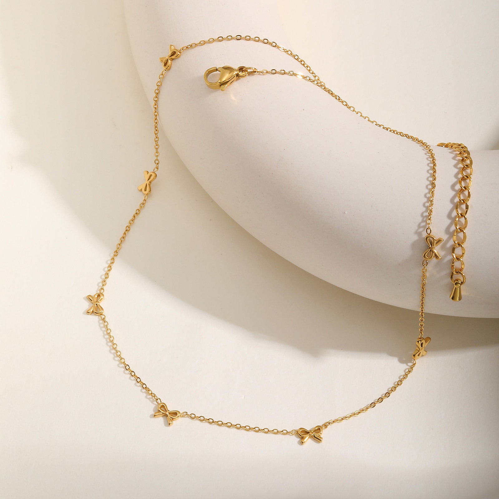 European and American style stainless steel necklace with flat cross chain and bow pendant, showcasing a stylish and elegant design.